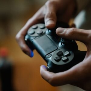 Photo by Eren Li Crop anonymous male pressing buttons on console controller while playing video game in house on blurred background