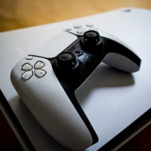 Photo by Pascal 📷 Detailed shot of a PlayStation 5 controller resting on the console, highlighting modern gaming design.